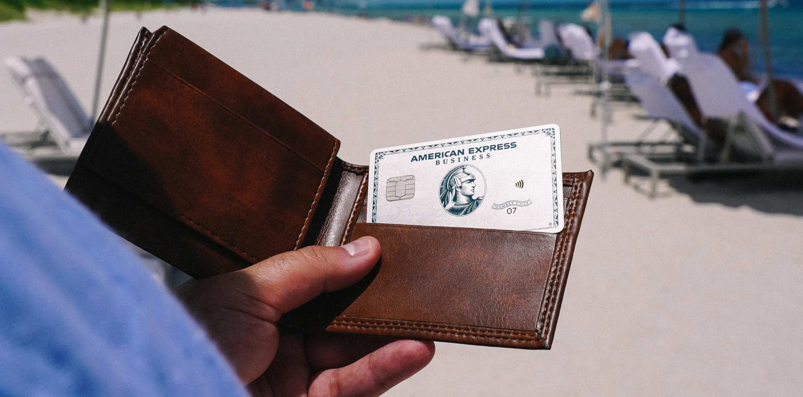 Wallet with card poking out on a beach