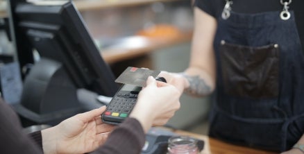 Person Holding Credit Card and paying using a card machine