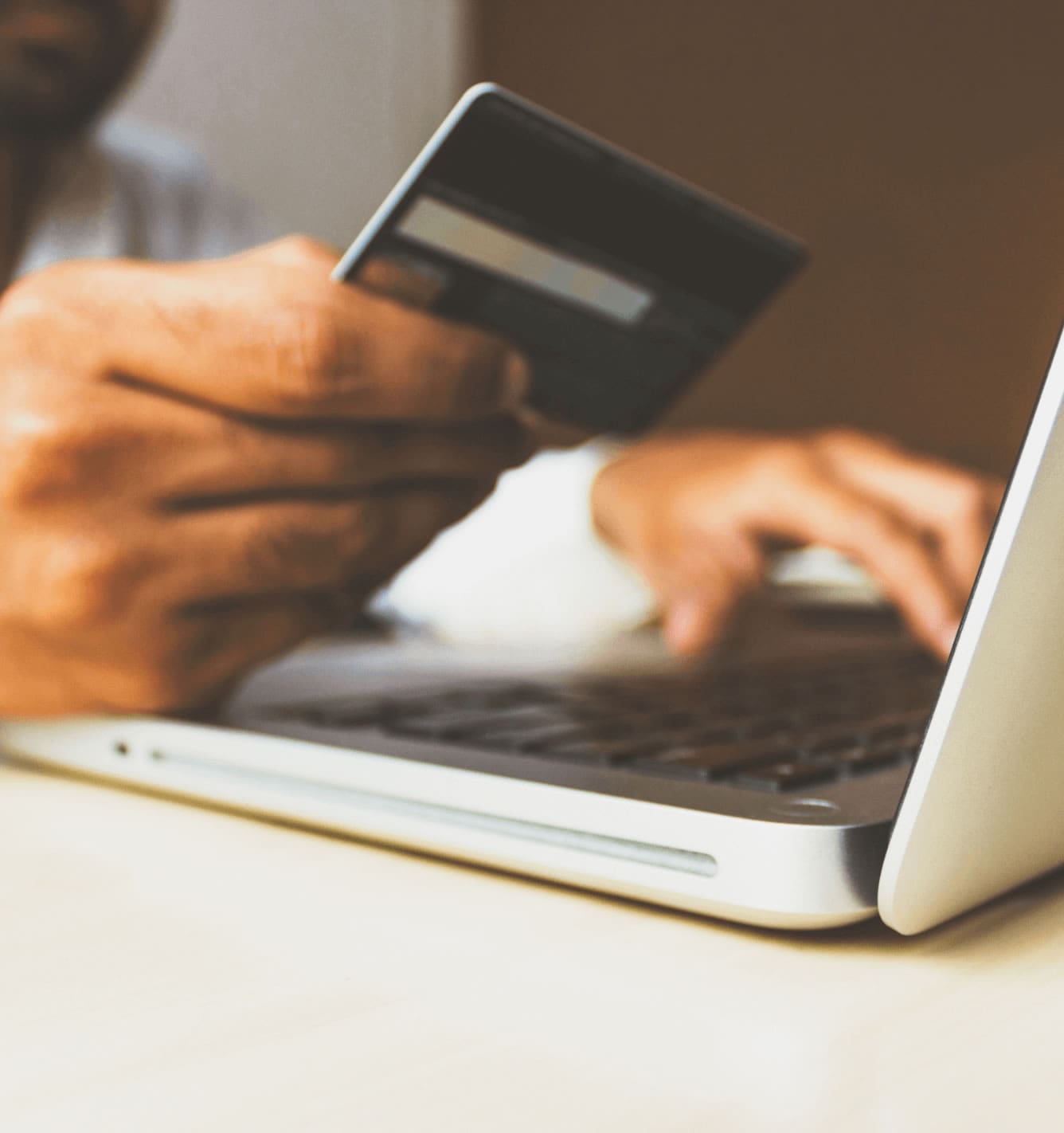 person making a payment on a laptop using their card