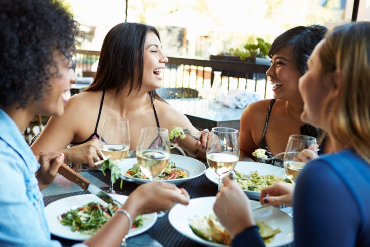 Group Of Female Friends Enjoying Meal Dining At Outdoor Restaurant Group Of Female Friends Enjoying Meal Dining At Outdoor Restaurant