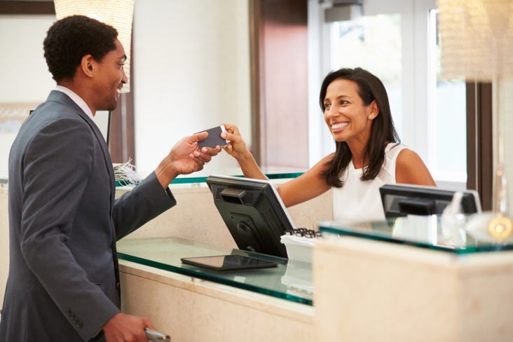 Businessman Checking In At Hotel Reception Front Desk Businessman Checking In At Hotel Reception Front Desk