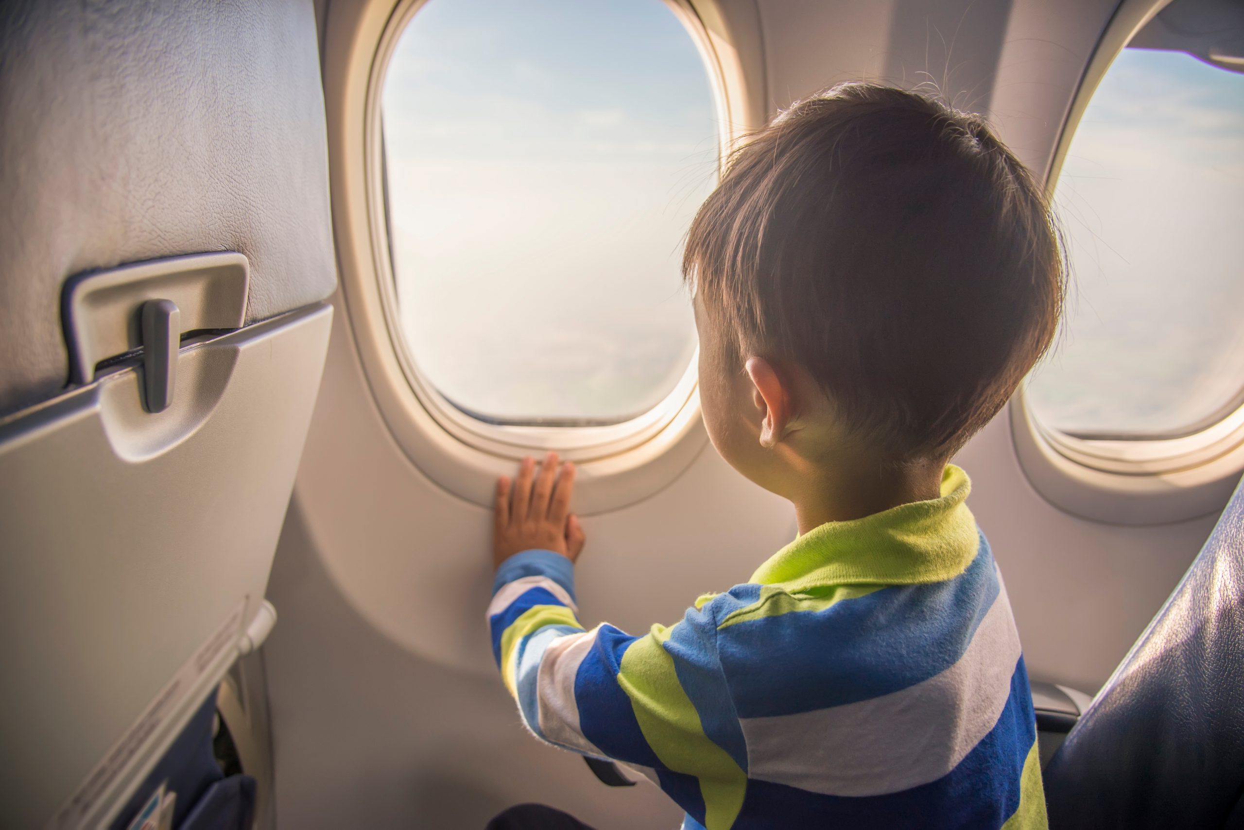Boy looking out of window on airplane