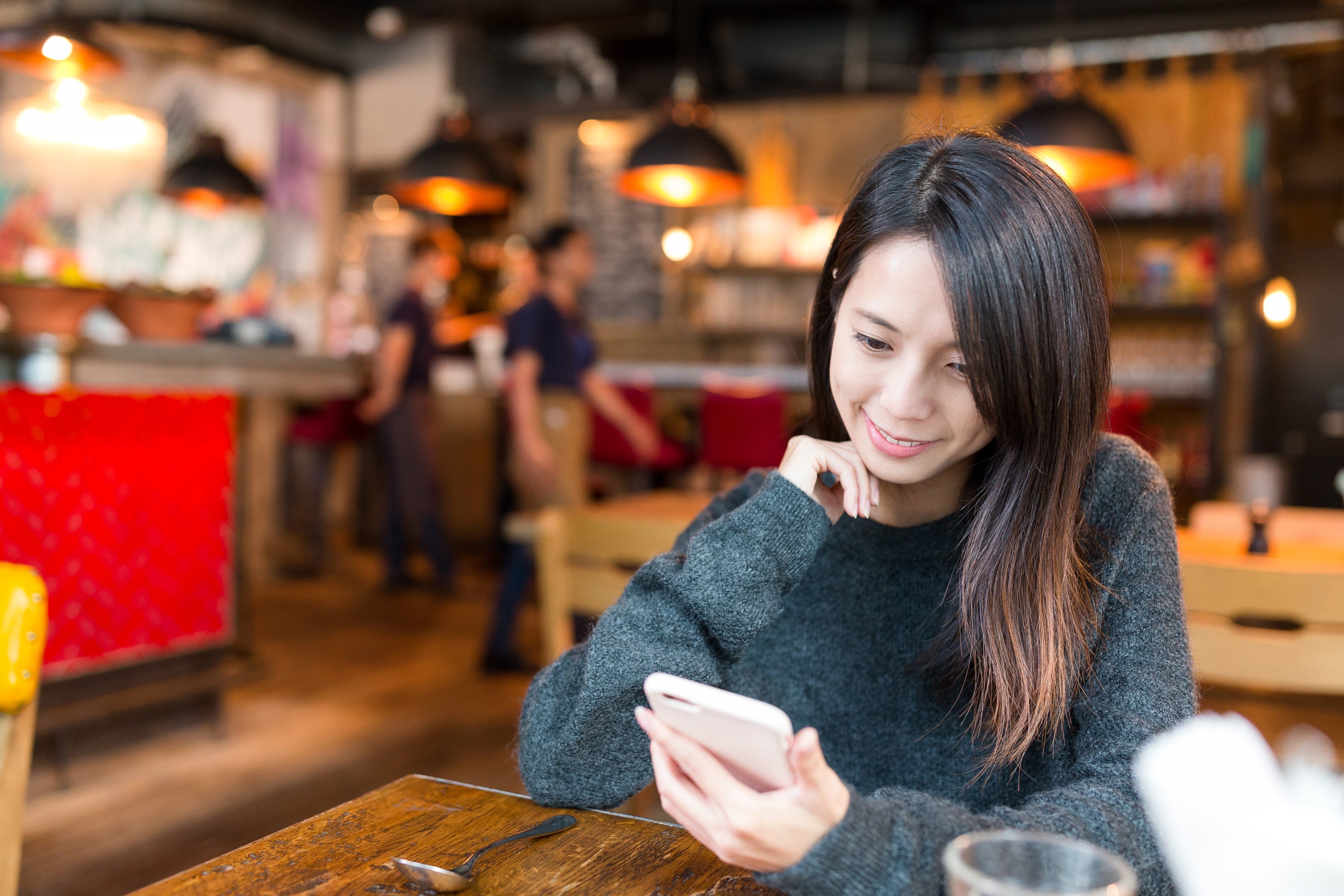 Woman looking at cellphone in coffee shop