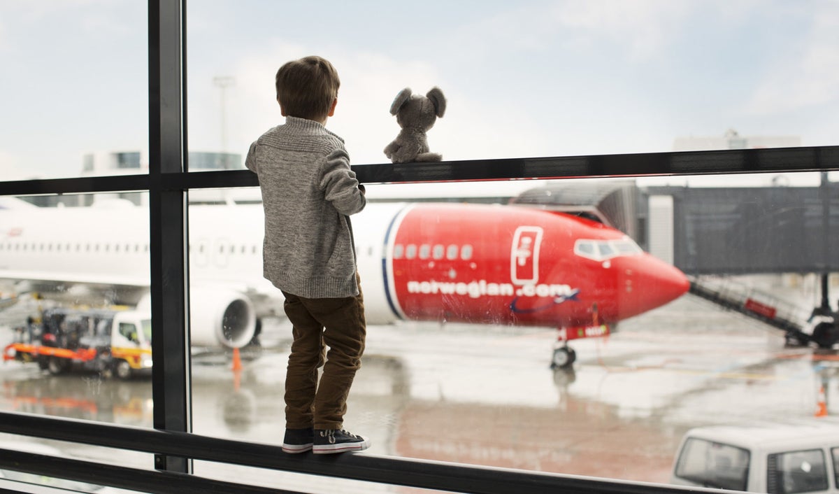 Little Boy Looks Out At Norwegian Plane
