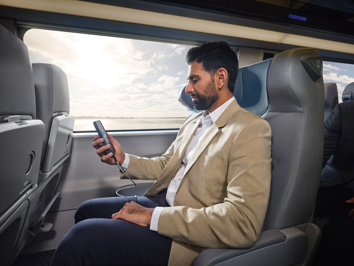Amtrak NextGen Acela passenger using phone