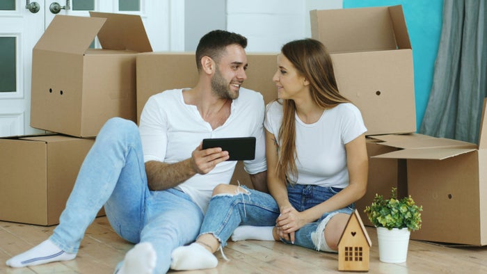 Couple with tablet and moving boxes in home