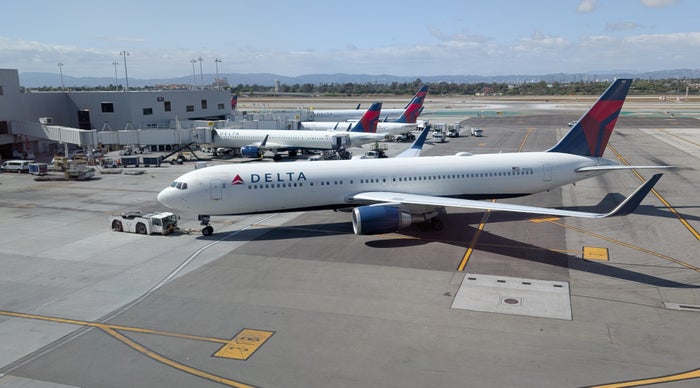 An airplane in the colors of Delta Air Lines pushed back from the gate at the Los Angeles airport
