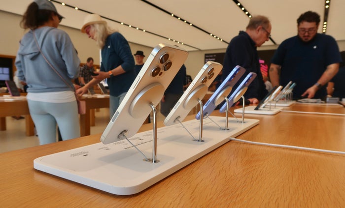 Business woman taking order on cell phone Interior of Apple Store With iPhones Lined Up Upgraded Points LLC 3