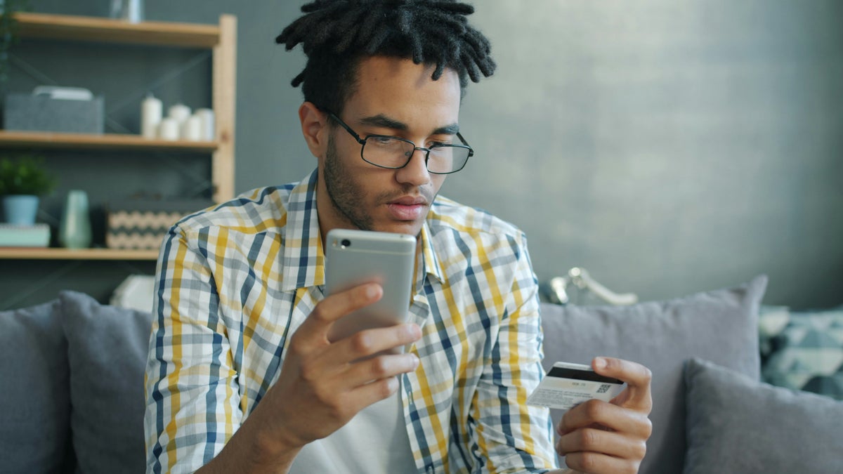 Man with credit card looking at phone