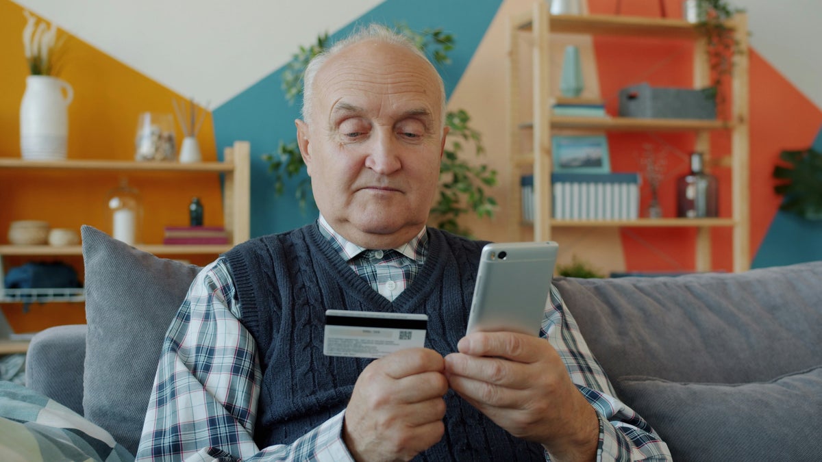 Senior elderly man with phone credit card