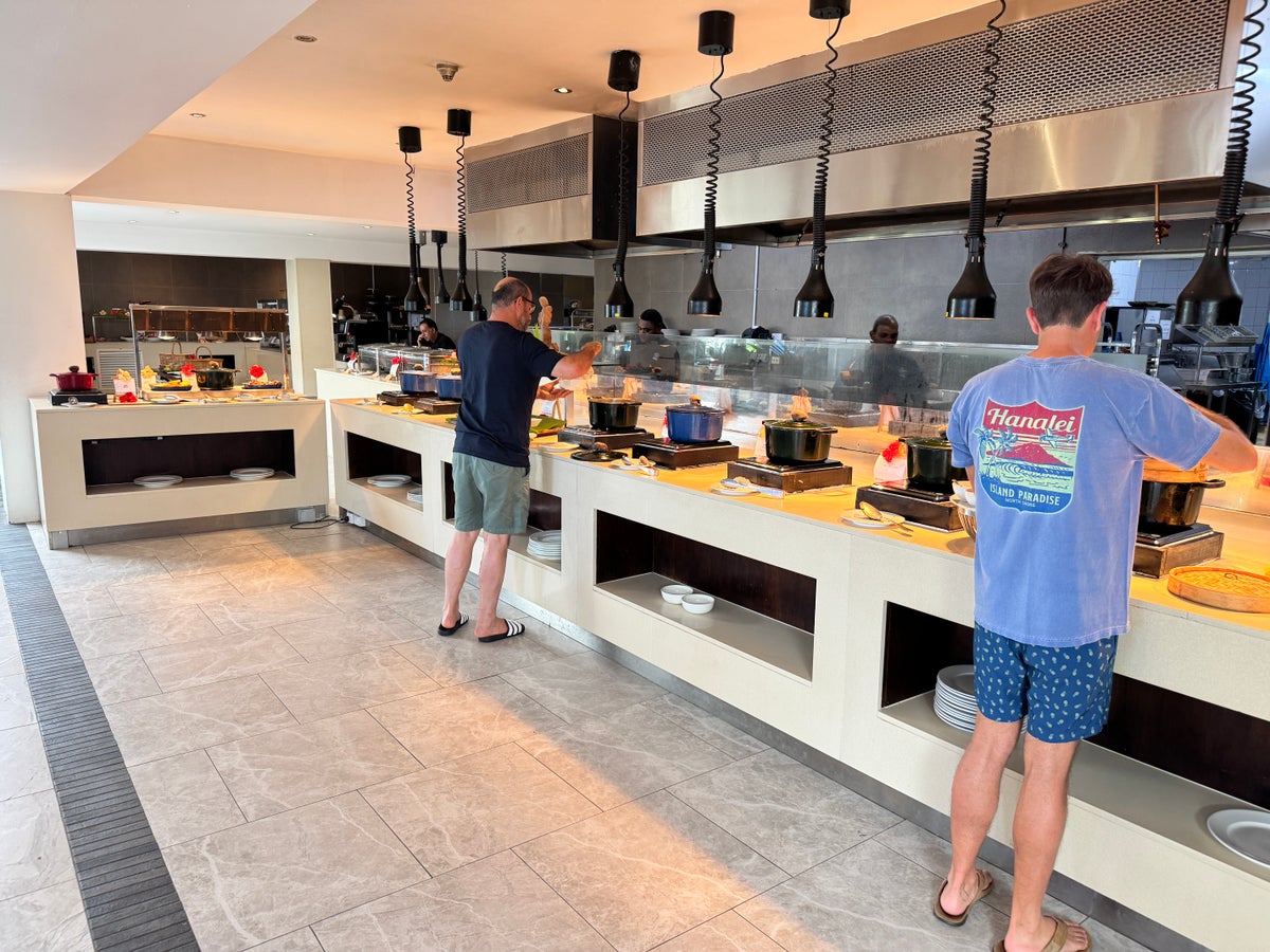 Sheraton Tokoriki Island Guests serving themselves at hot buffet stations with chef assistance