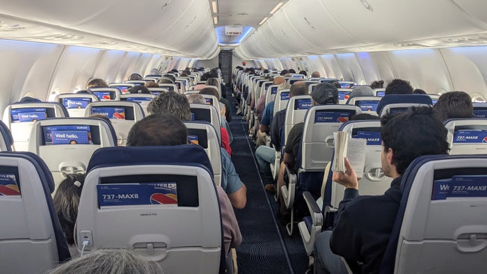 Southwest 737 Max 8 cabin An airplane cabin with passengers seated and viewed from behind