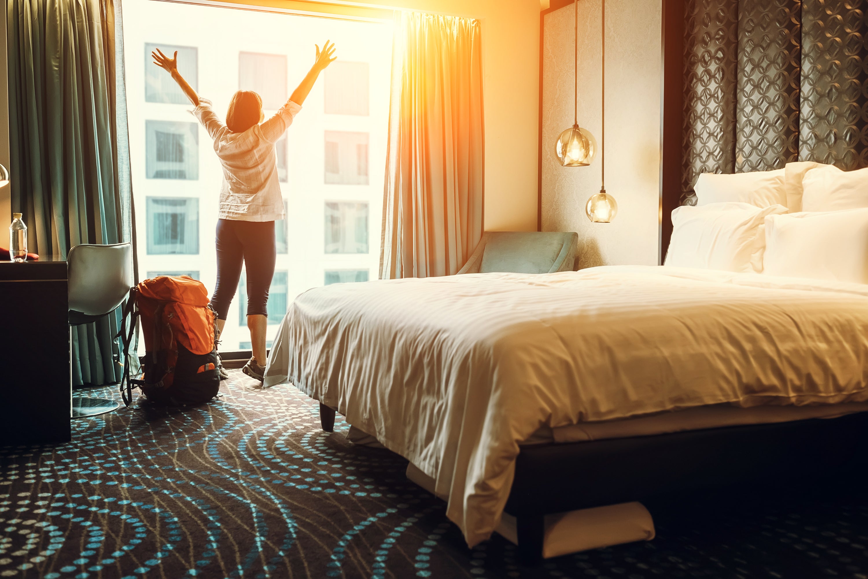 Woman throwing open hotel curtains