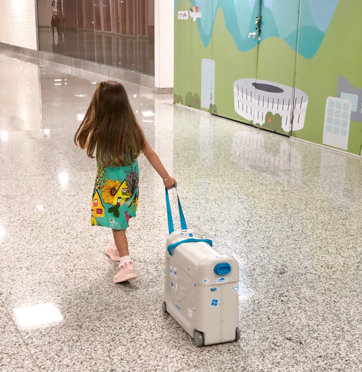Little Girl Pulling Luggage In The Airport