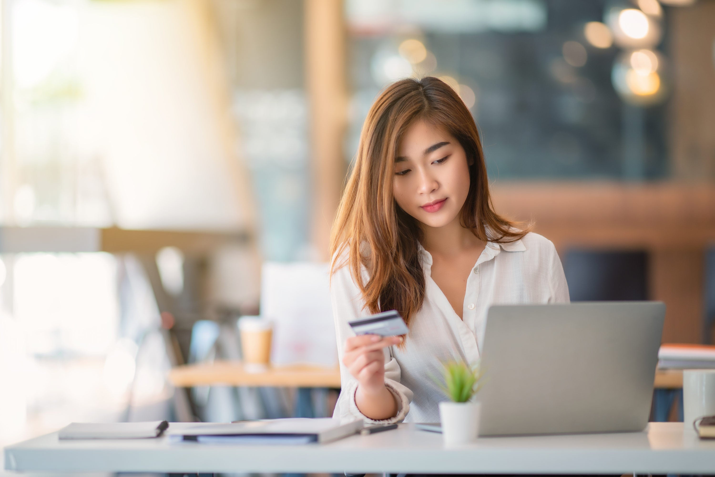Woman shopping on laptop with card