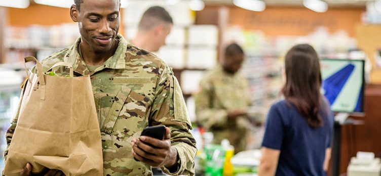 Soldier using phone at grocery store