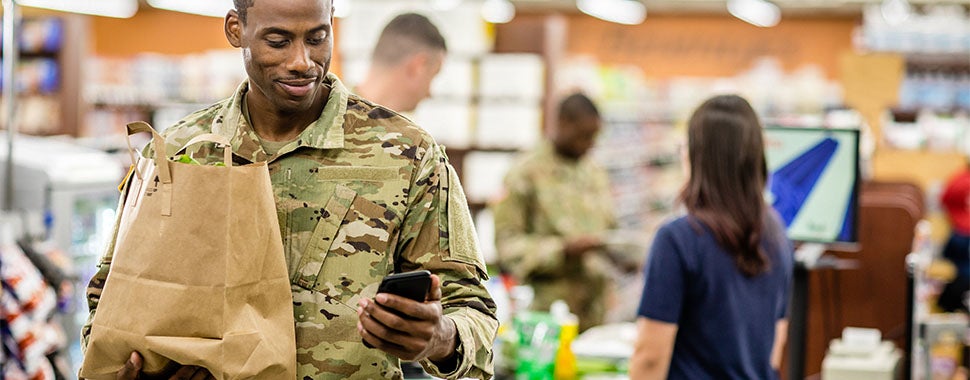 Soldier using phone at grocery store