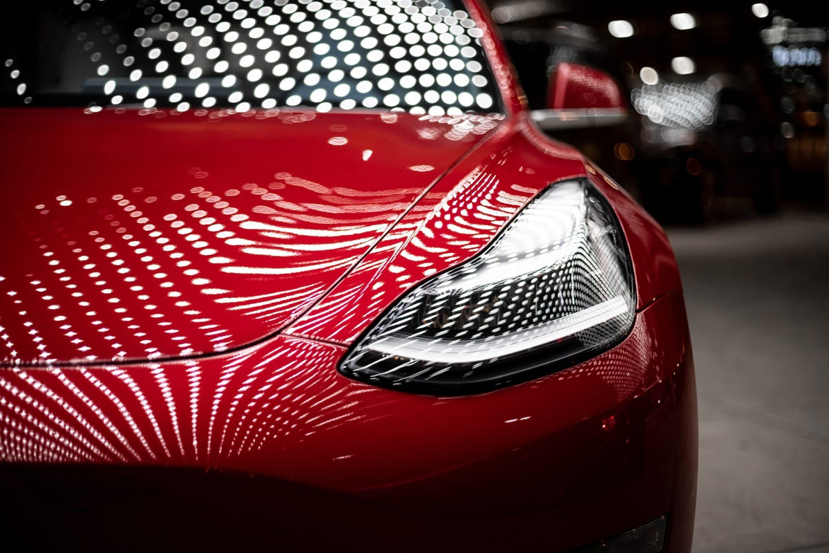Red Tesla Under Lighting
