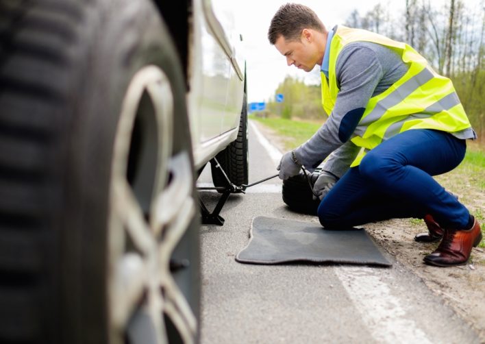 Man Changing Tire On A Car