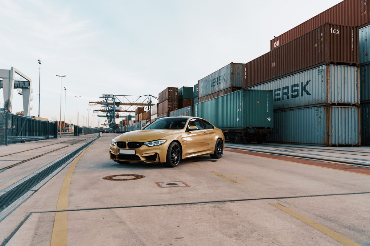 Gold BMW Near Shipping Containers