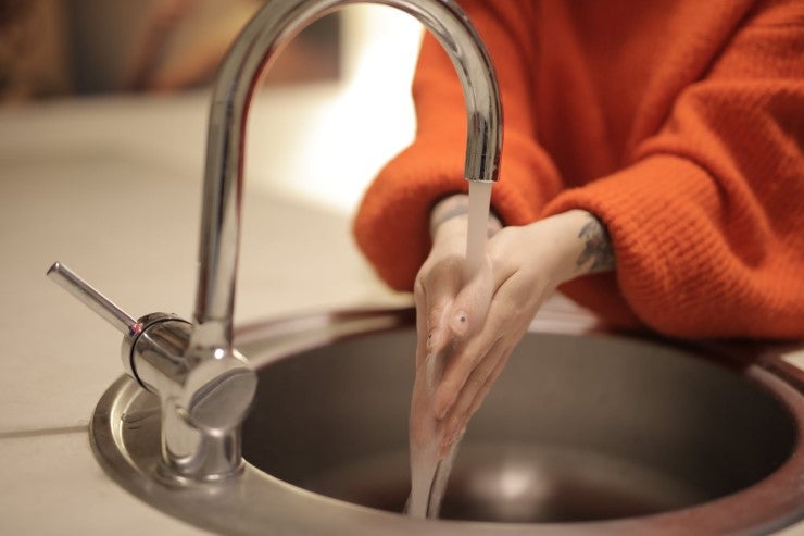 Woman Washing Her Hands In A Sink