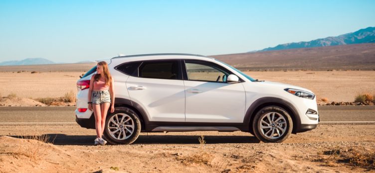 Girl by rental car in the desert