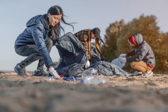 A group of people do a beach clean up A group of people do a beach clean up
