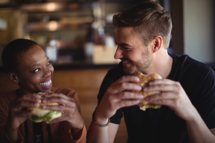 Happy couple having burger in restaurant Happy couple having burger in restaurant