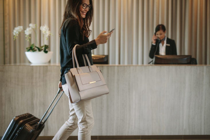 Guest checking phone at hotel check-in desk Guest checking phone at hotel check-in desk