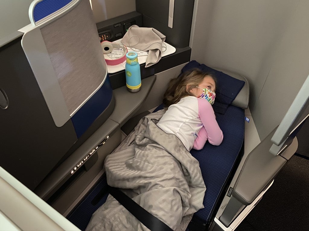 Girl sleeping in United Polaris lie flat bed