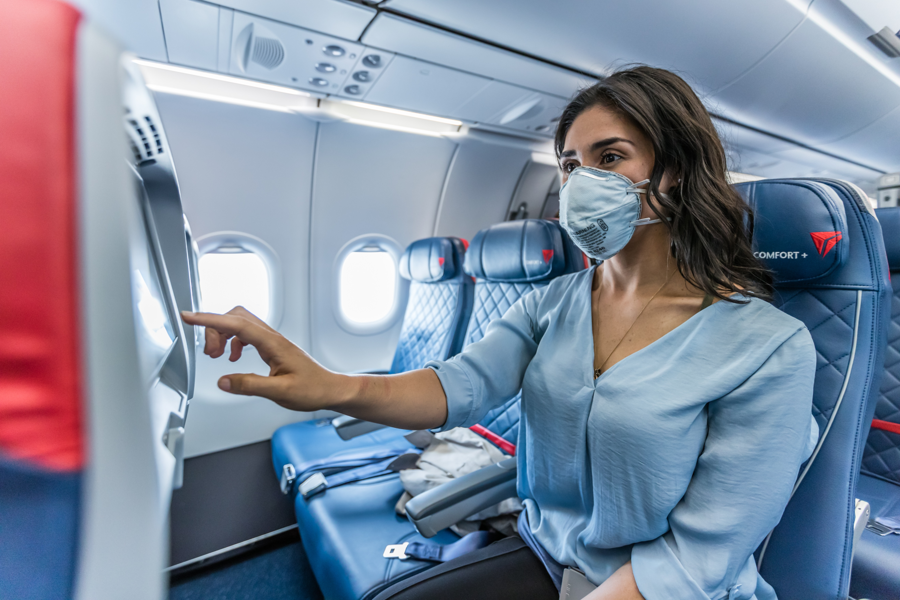 Woman wearing a face mask flying Delta