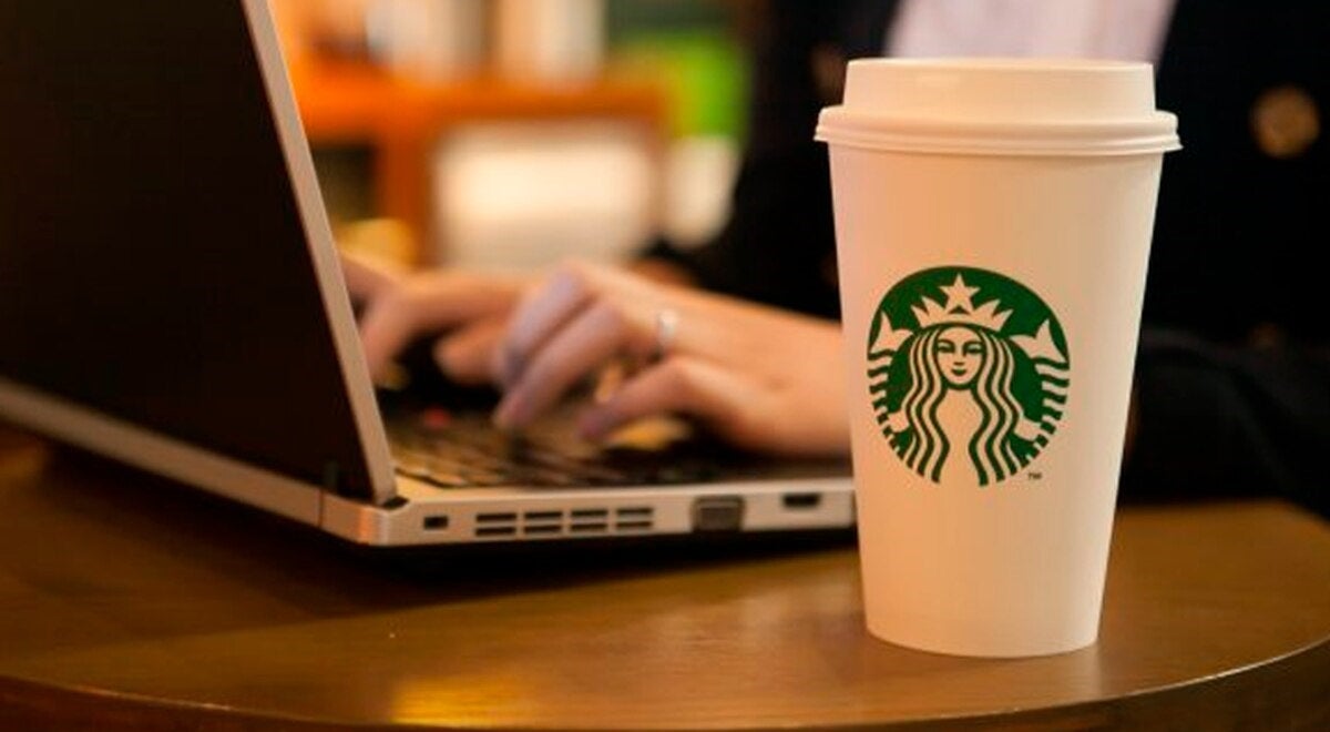 Starbucks customer with drink and laptop
