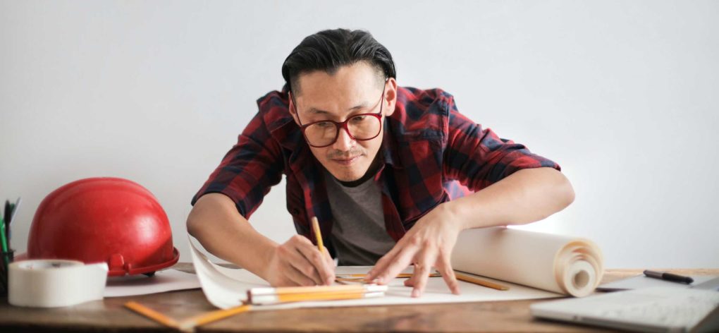 Man with glasses drawing on a table