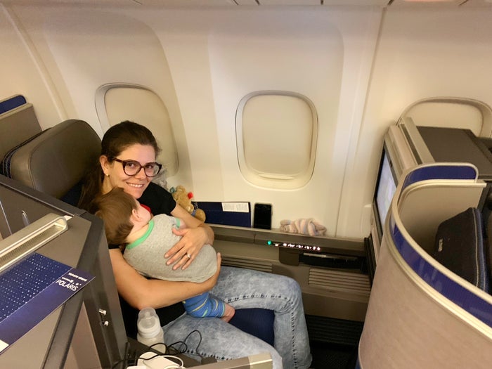 Baby looking out airplane window in bassinet Lap Child in United Polaris Business Class