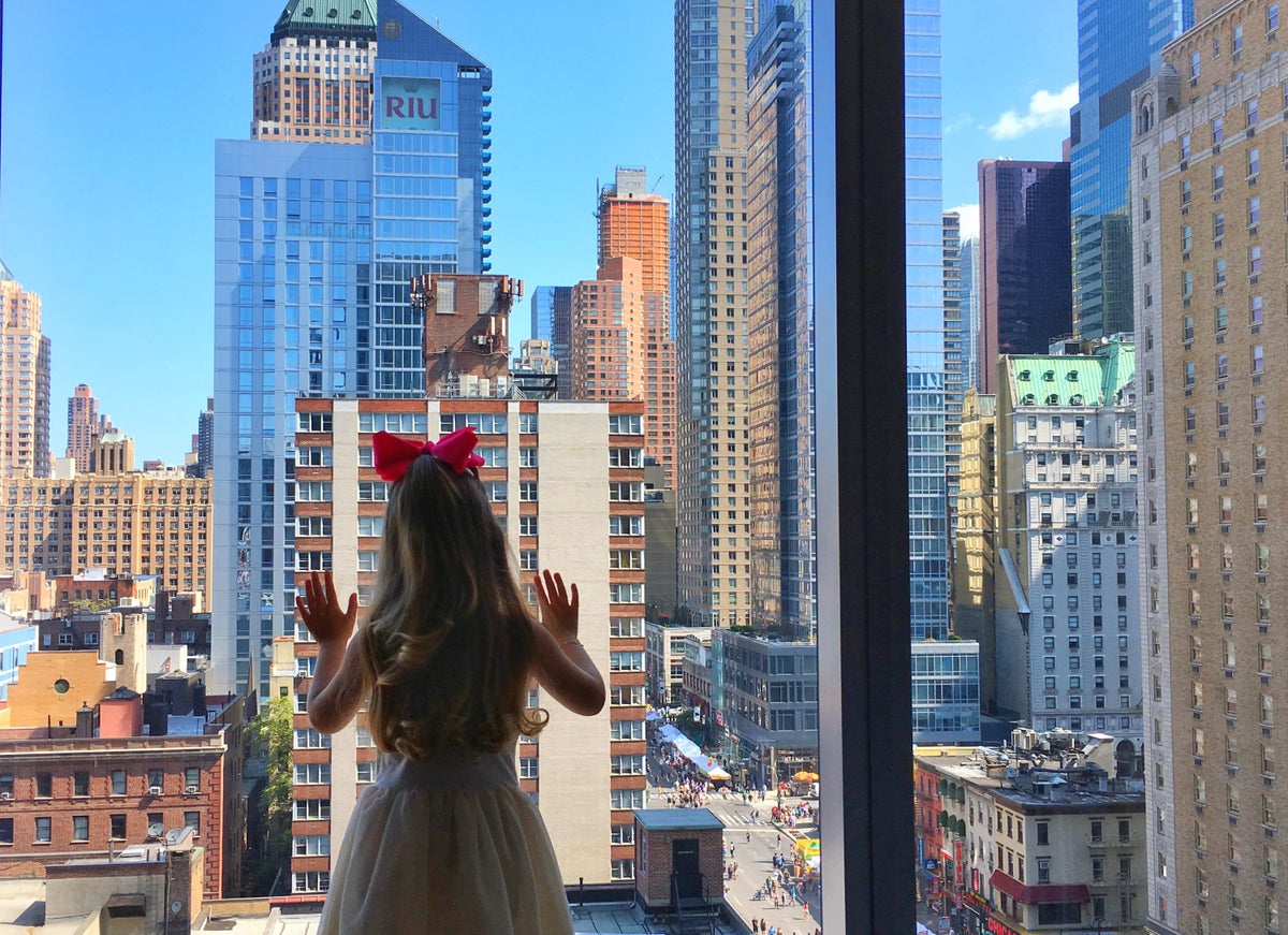 Girl looking out InterContinental IHG Hotel Window in Times Square New York