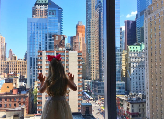 Girl looking out InterContinental IHG Hotel Window in Times Square New York Girl looking out InterContinental IHG Hotel Window in Times Square New York