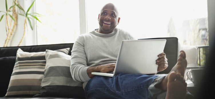 Happy man on couch with laptop