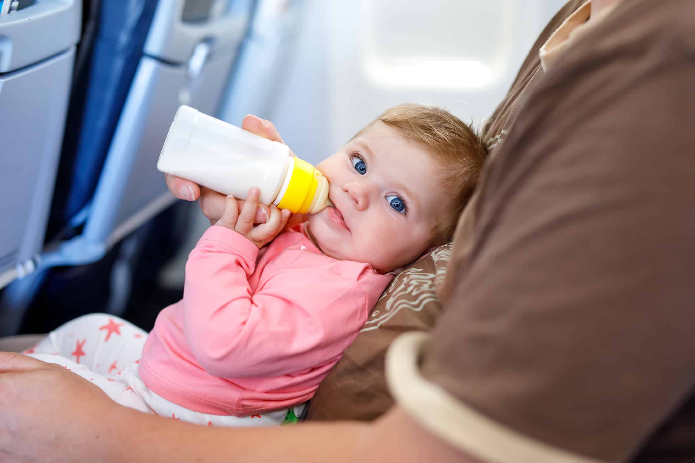 Lap child on plane drinking bottle