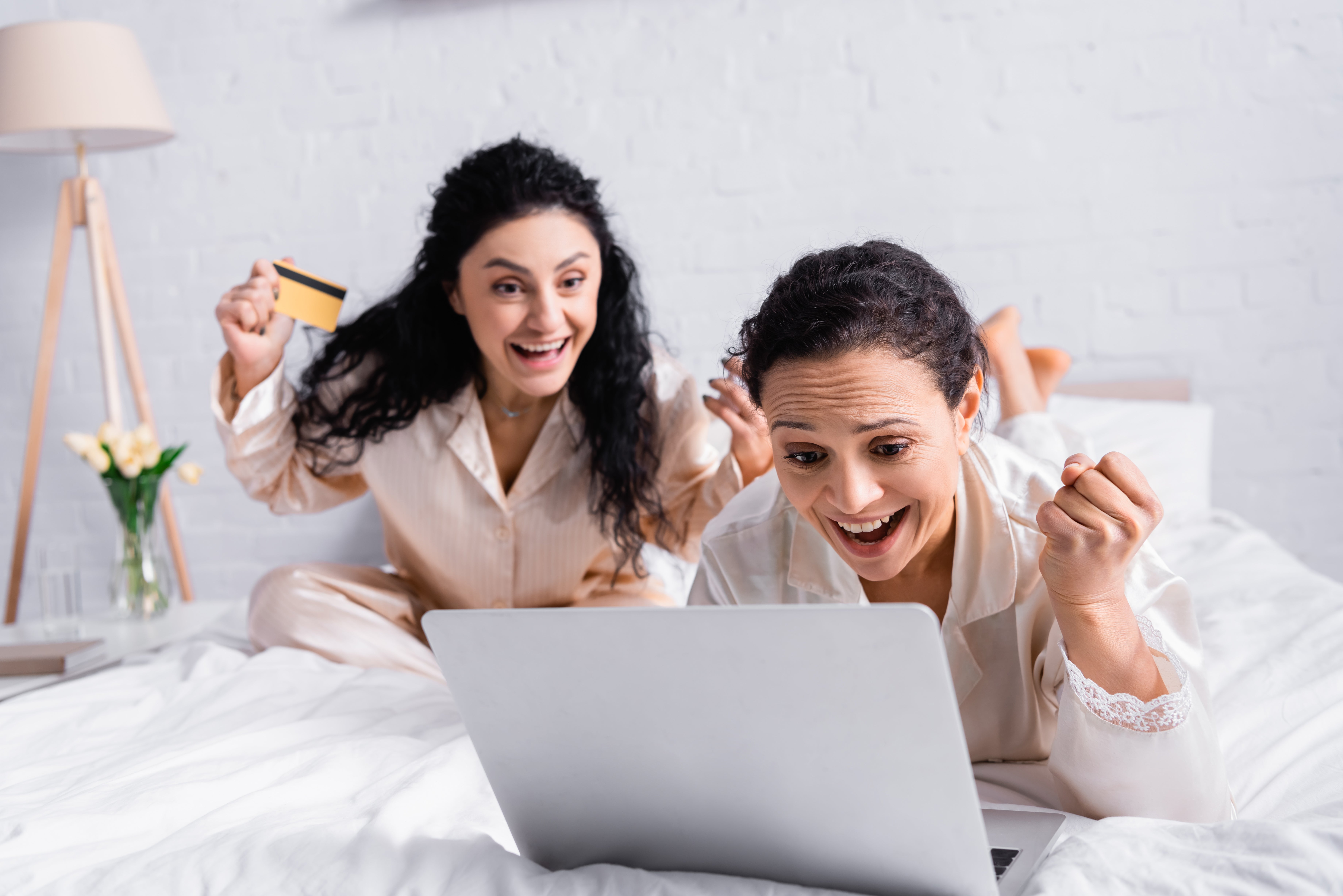 2 excited women on laptop with credit card