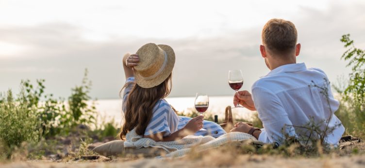 Couple drinking wine in grass on vacation