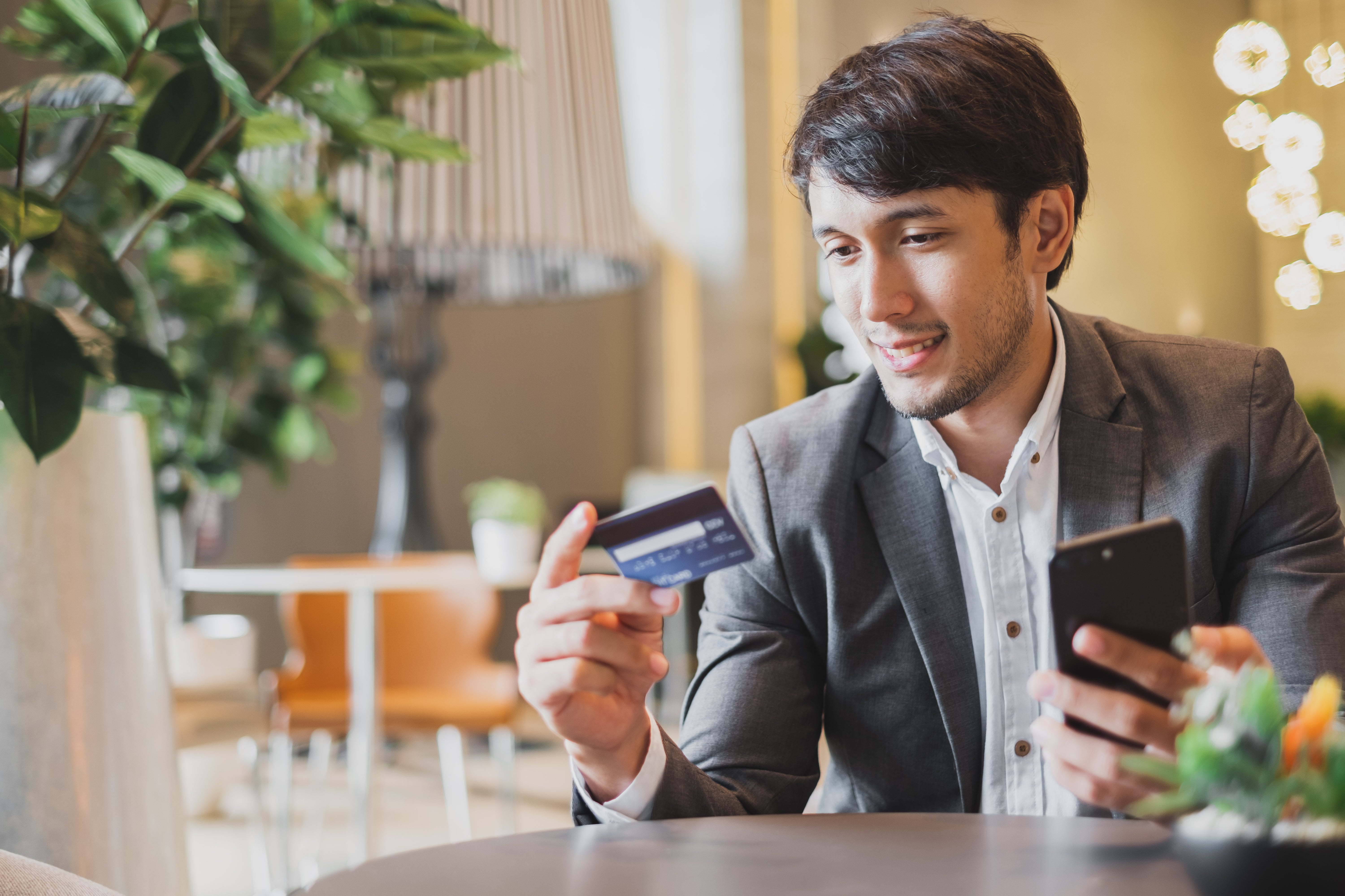 Businessman using credit card and mobile phone for online financial payment and shopping