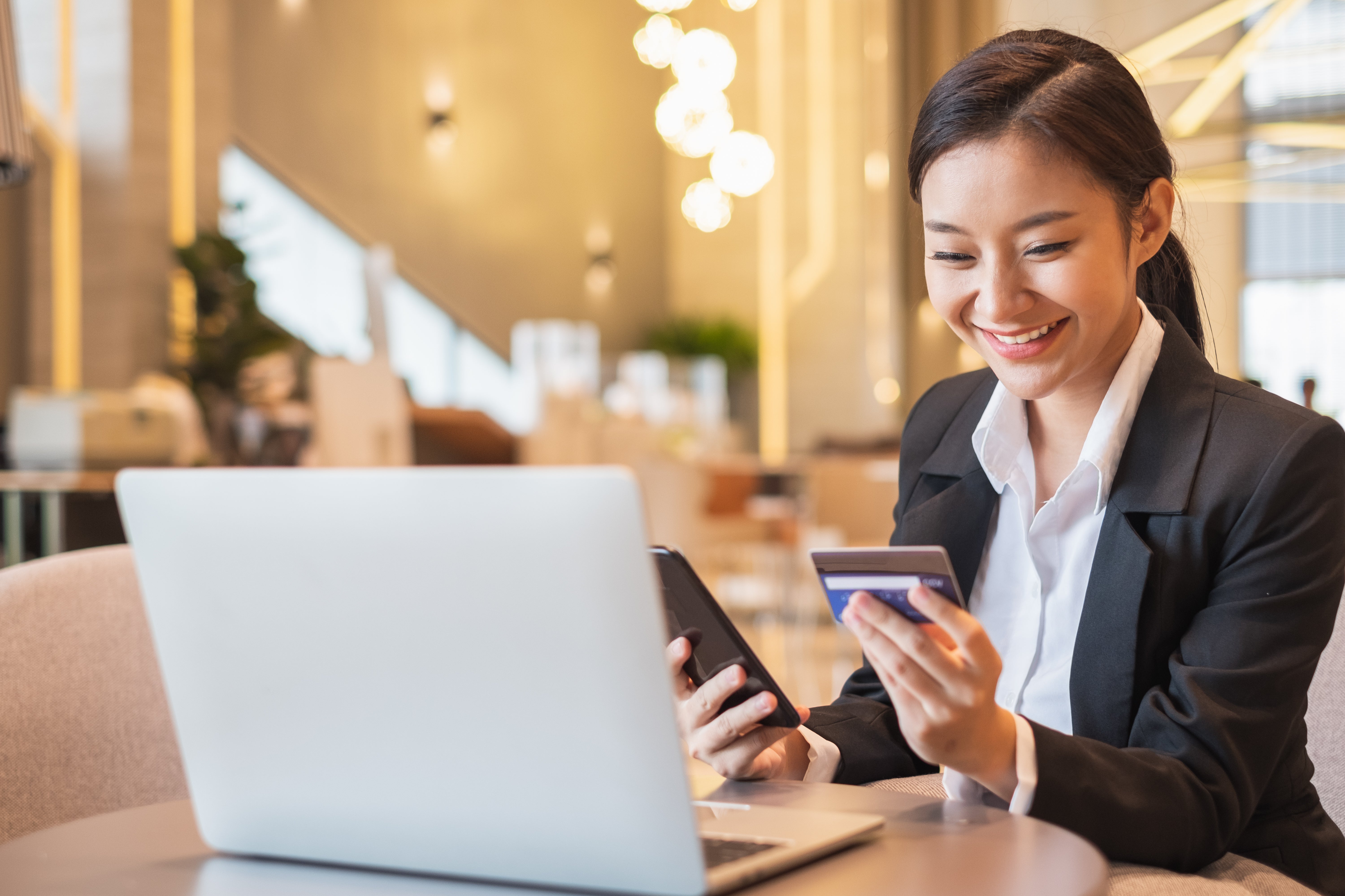 Businesswoman using credit card and mobile phone for online financial payment and shopping