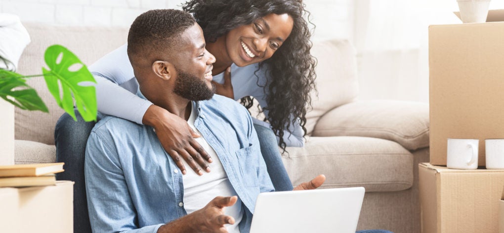 Couple smiling while on laptop computer