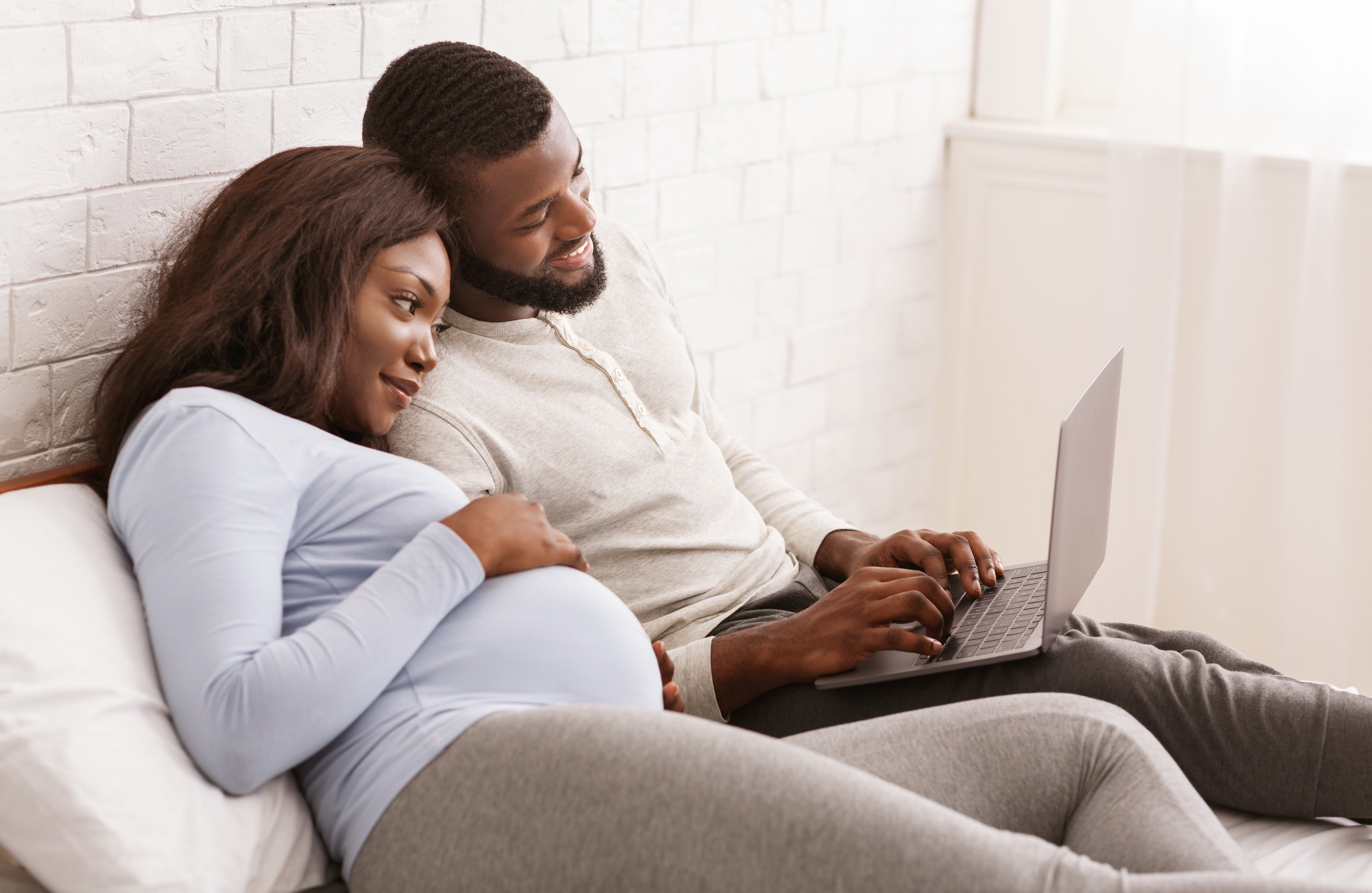 Pregnant woman and man on laptop computer