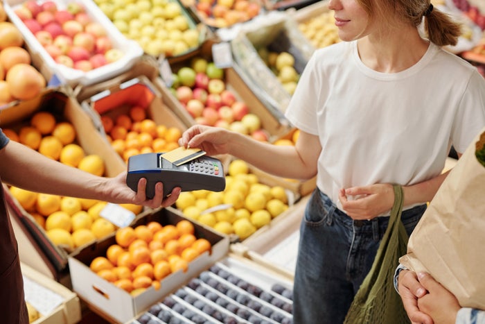 Woman paying for groceries at supermarket