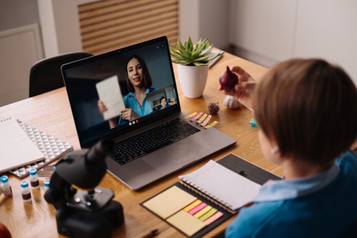 Teaching classroom preteen boy uses laptop make video call with his teacher