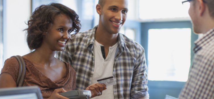 Couple paying at counter with credit card