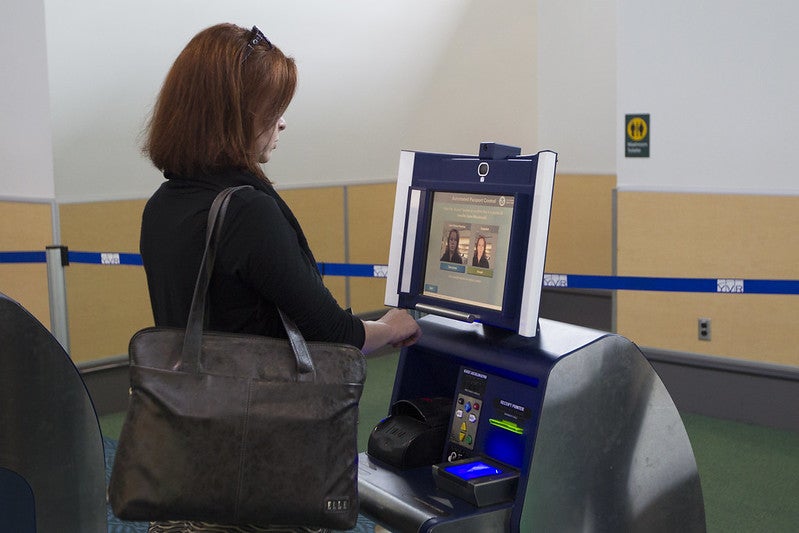 Woman using Global Entry kiosk