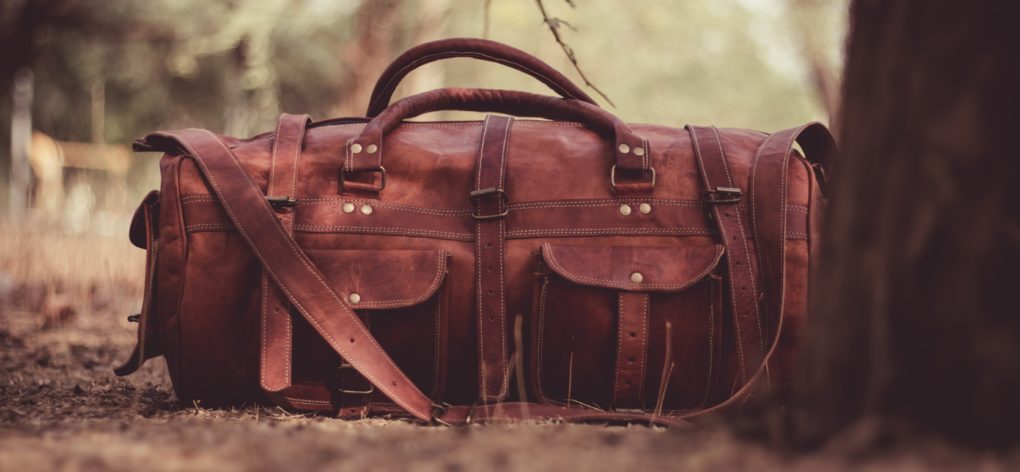 leather duffel in woods