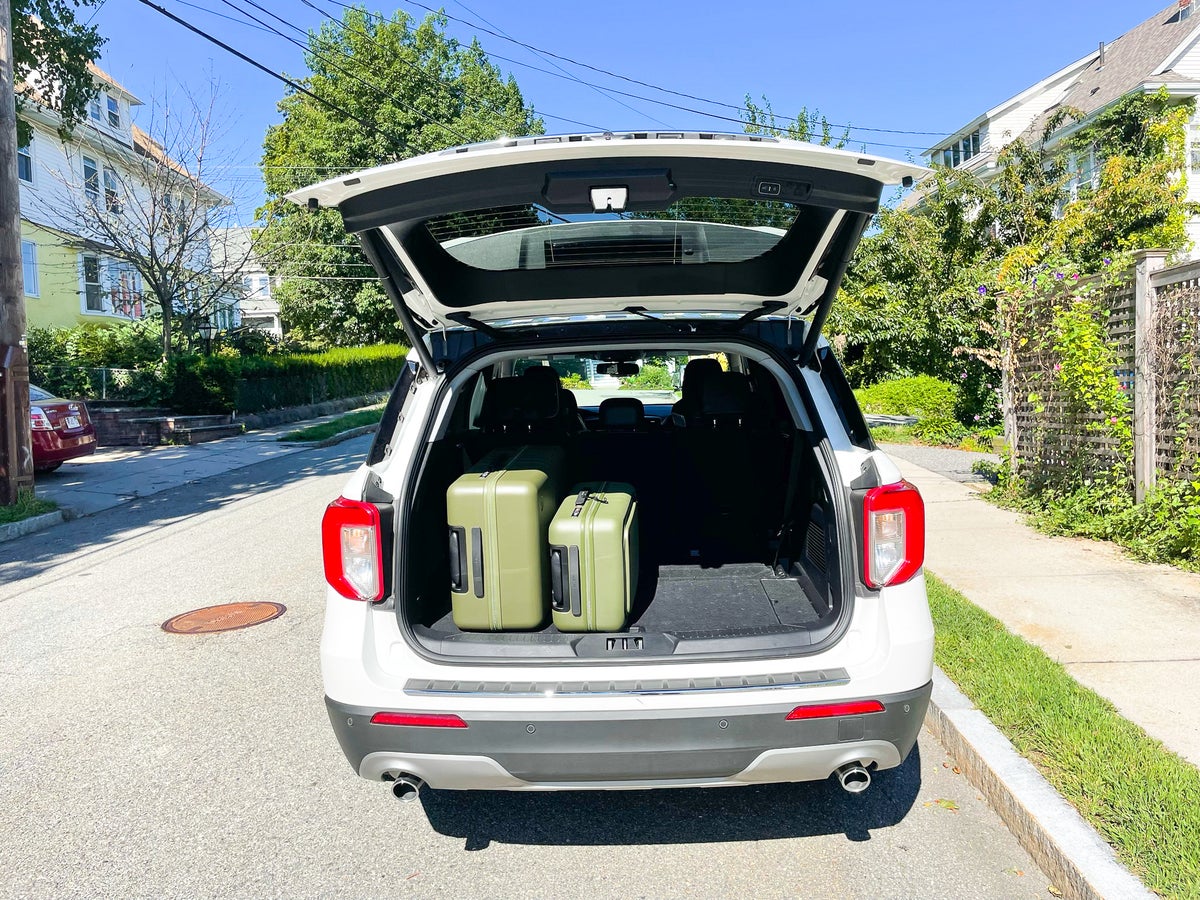 Olive Green Monos Luggage in a rental car